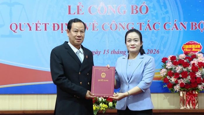 Đồng chí Nguyễn Hải Trâm, Phó Chánh án Tòa án nhân dân tối cao trao quyết định và tặng hoa chúc mừng đồng chí Vũ Văn Minh, tân Chánh án Tòa án nhân dân tỉnh Quảng Trị - Ảnh: Thùy Trang