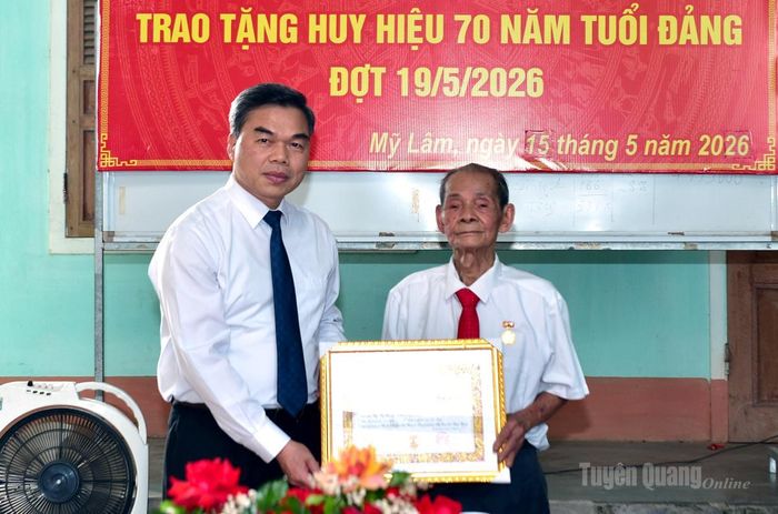 Phó Bí thư Tỉnh ủy, Chủ tịch Ủy ban MTTQ Việt Nam tỉnh Ma Thế Hồng trao Huy hiệu 70 năm tuổi Đảng cho đồng chí Hoàng Như Đức.