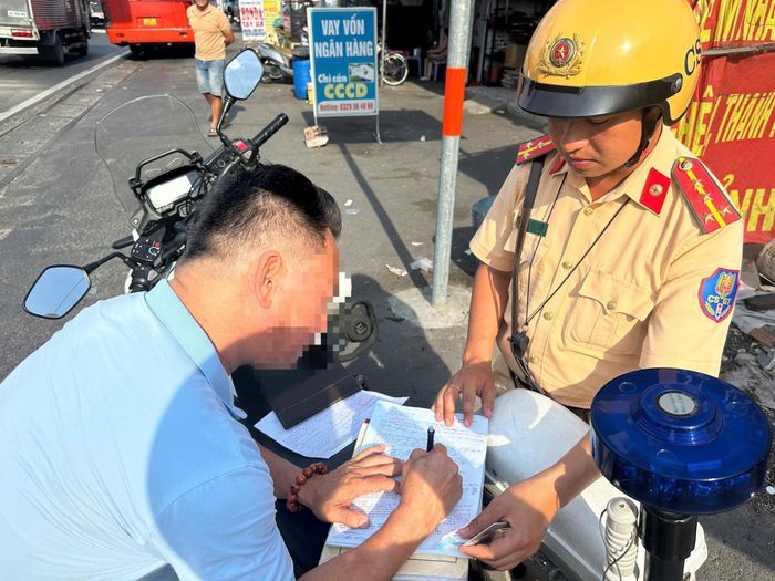 Tài xế ký biên bản vi phạm.