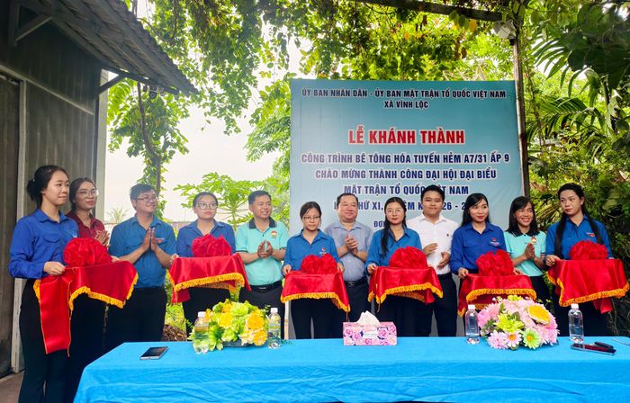  Lãnh đạo xã Vĩnh Lộc cắt băng khánh thành công trình bê tông hóa và trao tặng cờ Tổ quốc cho đại diện các hộ dân tại tuyến hẻm ở Ấp 9. Ảnh: N.TÂN 
