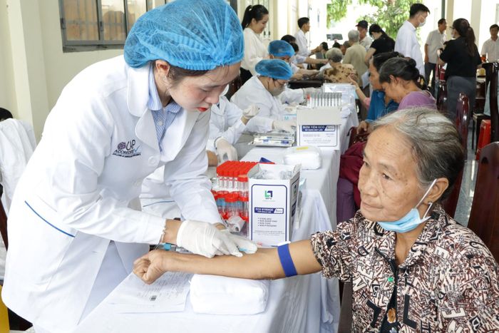  Nhân viên y tế lấy máu làm xét nghiệm các chỉ số sinh hóa cho bà Đặng Thị Giúp tại buổi khám sức khỏe ở xã Nhơn Ái. Ảnh: NHẪN NAM 