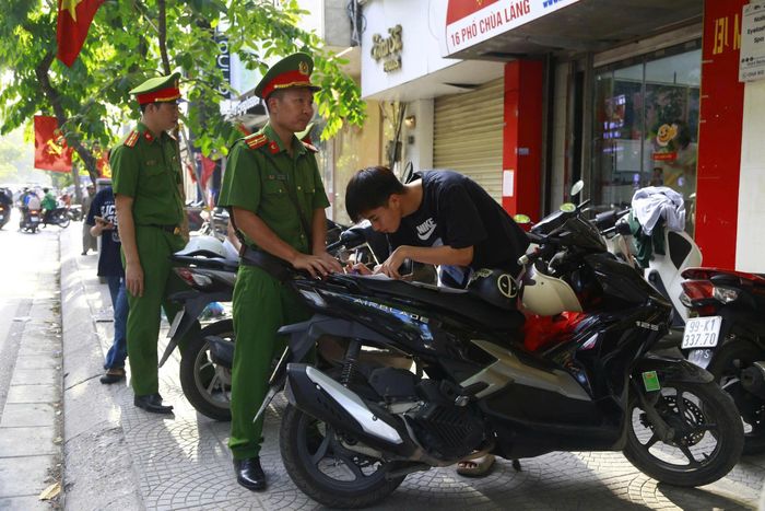  Lực lượng công an phường Láng tuần tra và xử phạt người vi phạm, lấn chiếm vỉa hè tại phố Chùa Láng, ngày 15-5. Ảnh: HÀ NGUYỄN 