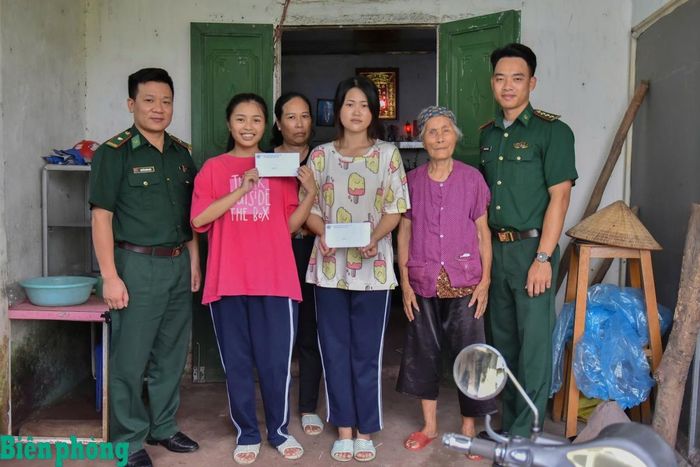 Thiếu tá Nguyễn Năng Hiệp (ngoài cùng, bên trái) trao học bổng cho các em học sinh trong Chương trình “Nâng bước em tới trường-Con nuôi đồn Biên phòng”. Ảnh: Ngọc Toàn