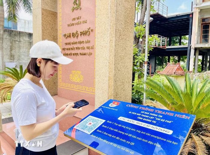 Du khách đến từ tỉnh Đắk Lắk trải nghiệm quét mã QR tại di tích nơi thành lập “Chi bộ phố” tỉnh Quảng Trị (Chi bộ Đảng Cộng sản Việt Nam đầu tiên của thị xã Đồng Hới được thành lập). (Ảnh: Võ Dung/TTXVN)