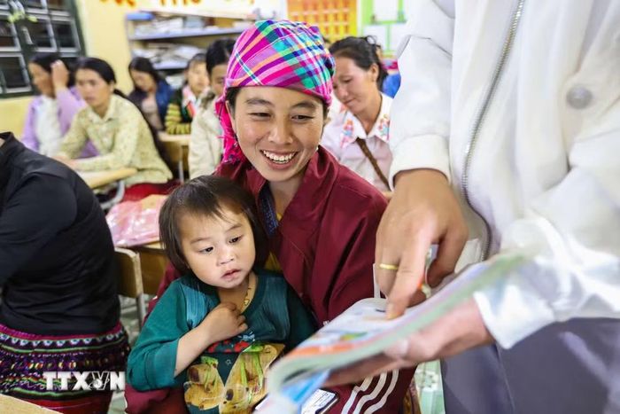 Học sinh Hạng Thị Cha đọc theo hướng dẫn của thầy giáo trên sách giáo khoa tiếng việt lớp 1. (Ảnh: Trọng Đạt/TTXVN)