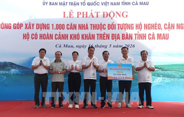 Khối Chính quyền cấp tỉnh trao tặng bảng tượng trưng 65 căn nhà trị giá 5,2 tỷ đồng. Ảnh: Tuấn Phi - TTXVN
