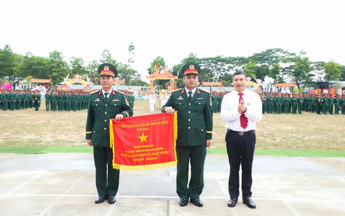Phó Chủ tịch Thường trực UBND thành phố Hồ Kỳ Minh trao Cờ của UBND thành phố cho đơn vị, với nội dung “Trung đoàn 971, Bộ Chỉ huy Quân sự thành phố 40 năm xây dựng và phát triển”. Ảnh: NGỌC PHÚ