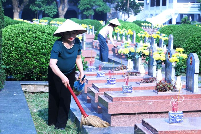Bà Nguyễn Thị Miến cùng đồng nghiệp chăm sóc phần mộ liệt sĩ tại Nghĩa trang Liệt sĩ quốc gia A1.