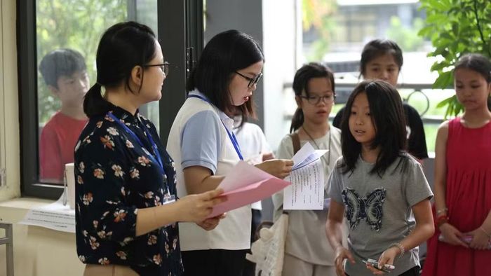Cán bộ coi thi kiểm tra thông tin và gọi thí sinh vào phòng thi. (Ảnh: ĐẠI THẮNG)
