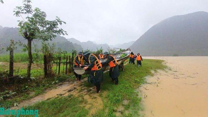 Cán bộ, chiến sĩ Đồn Biên phòng Làng Mô giúp dân di dời tài sản ra khỏi khu vực nguy hiểm do ảnh hưởng của lũ lụt. Ảnh: Huy Hoàng