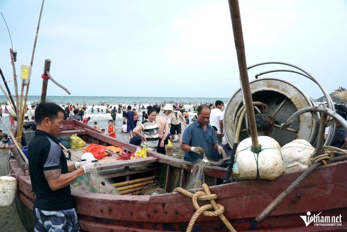 Ngư dân đang gỡ hải sản dính lưới sau chuyến ra khơi
