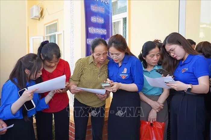 Các đơn vị giới thiệu và hướng dẫn quy trình sử dụng ứng dụng công dân số "i-HaTinh" cho người dân địa phương. Ảnh: Hoàng Ngà/TTXVN