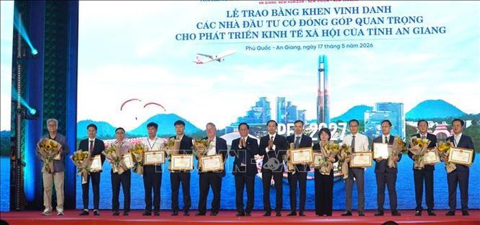 Trao tặng Bằng khen của Chủ tịch UBND tỉnh An Giang cho các nhà đầu tư. Ảnh: Văn Sĩ/TTXVN
