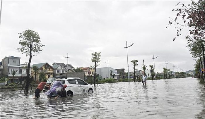 Có người phải đẩy xe ô tô do chết máy giữa đường vì ngập nước.