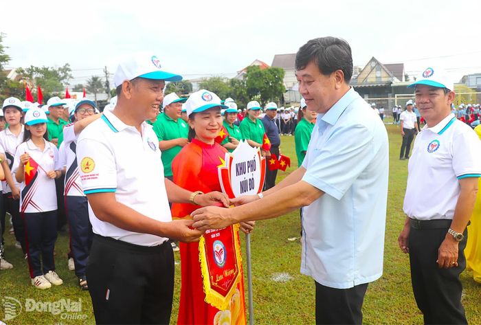 Phó Giám đốc Báo và Phát thanh, Truyền hình Đồng Nai Hoàng Bình Long tặng cờ lưu niệm cho các đơn vị tham dự lễ khai mạc. Ảnh: An Nhơn
