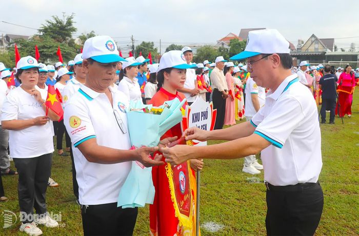 Bí thư Đảng ủy, Chủ tịch HĐND phường Xuân Lập Nguyễn Trung Tín tặng cờ lưu niệm cho các đơn vị tham dự lễ khai mạc. Ảnh: An Nhơn