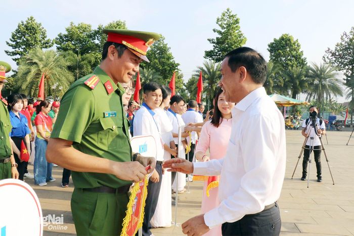 Bí thư Đảng ủy, Chủ tịch HĐND phường Đồng Xoài Vũ Văn Mười tặng cờ lưu niệm cho các đơn vị. Ảnh: Ngọc Thuận