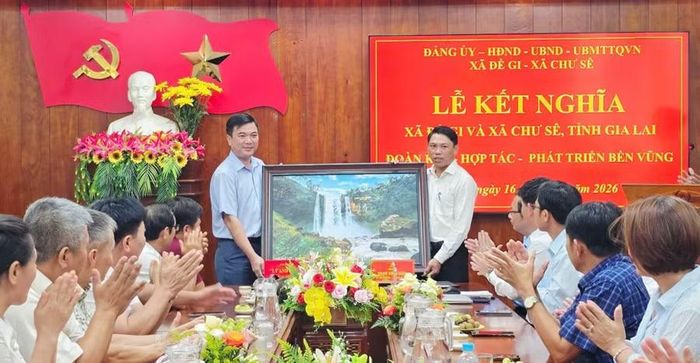  Xã Chư Sê trao tặng xã Đề Gi bức tranh thác Phú Cường cùng các sản phẩm OCOP đặc trưng của địa phương tại lễ kết nghĩa. Ảnh: Trịnh Thắm 