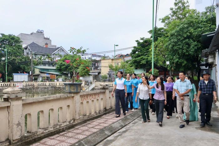 Người dân Tổ dân phố 4, 5, 6 Đình Quán cùng tham quan đoạn đường nở hoa. Ảnh: QA