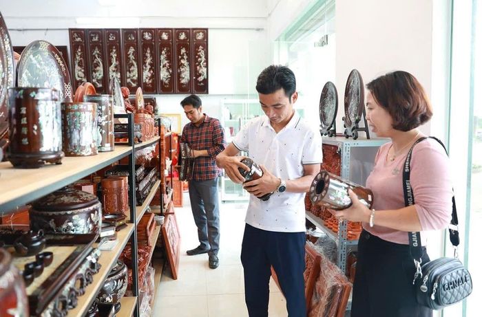 Du khách tham quan làng nghề khảm trai Chuôn Ngọ (xã Chuyên Mỹ). Ảnh: Quang Thái