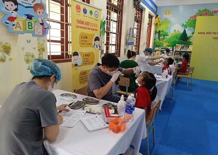 Các y bác sĩ nha khoa tham gia mô hình kết hợp công tư khám răng miệng cho học sinh Trường tiểu học Đồng Du.