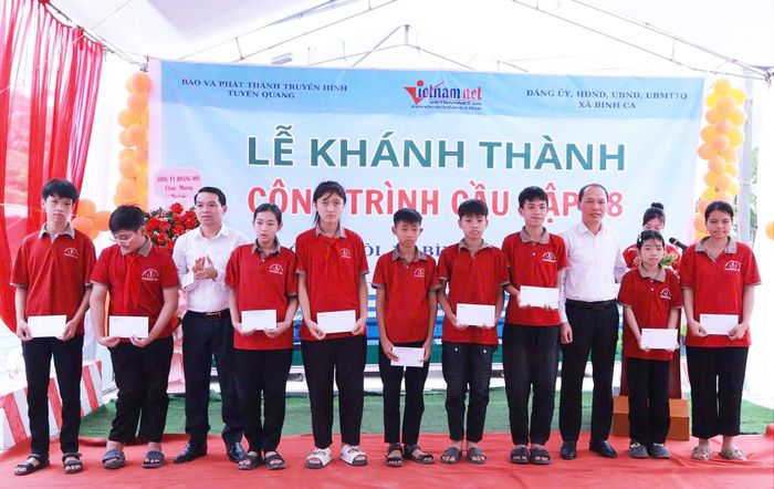 Ông Nguyễn Văn Dưng - Giám đốc Sở Dân tộc và Tôn giáo tỉnh Tuyên Quang và ông Dương Văn Hòa - Bí thư Đảng ủy xã Bình Ca, trao quà cho các em học sinh có hoàn cảnh khó khăn