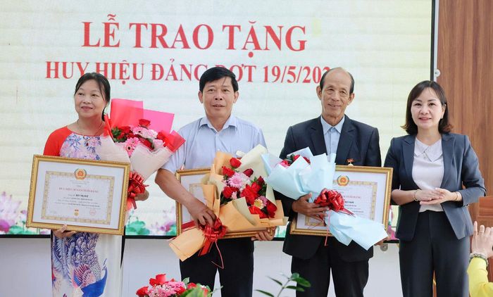 Phó Bí thư Thường trực Đảng ủy xã Nguyễn Thị Thùy Trinh trao Huy hiệu Đảng cho các đảng viên