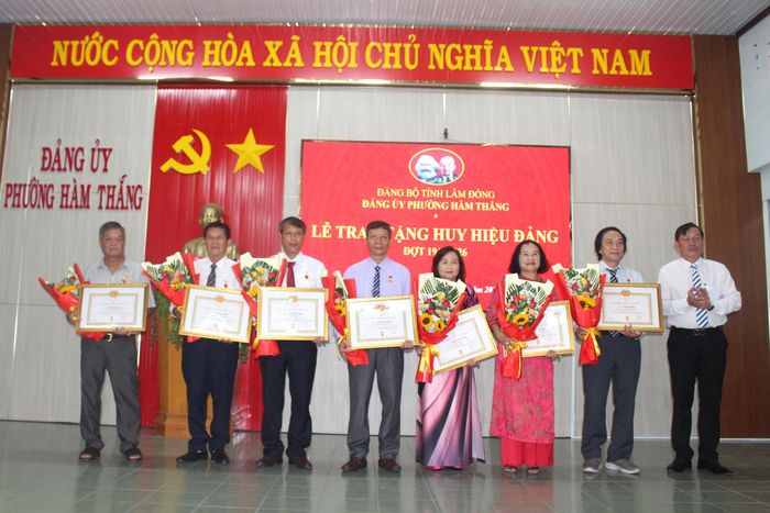 Ông Trần Ngọc Hiền, Chủ tịch UBND phường Hàm Thắng trao Huy hiệu 30 năm tuổi Đảng cho 8 đảng viên