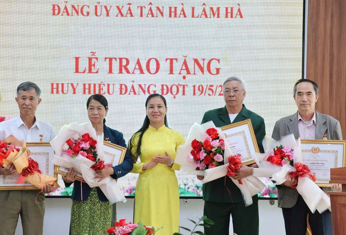 Đồng chí Giáp Thị Thủy, Bí thư Đảng ủy, Chủ tịch HĐND xã Tân Hà Lâm Hà trao Huy hiệu Đảng cho các đảng viên