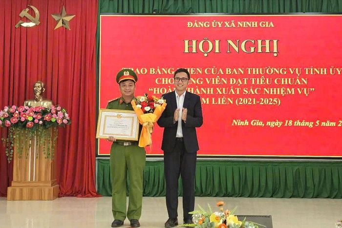 Đồng chí Nguyễn Trần Nhật Huy, Bí thư Đảng ủy, Chủ tịch HĐND xã trao Bằng khen của UBND tỉnh cho đồng chí Hồ Hoàng Quang Long, Chi ủy viên Chi bộ cơ sở Công an xã Ninh Gia