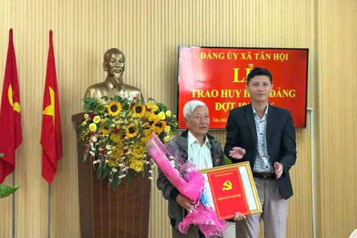 Đồng chí Hồ Quốc Trung, Bí thư Đảng ủy, Chủ tịch HĐND xã Tân Hội trao Huy hiệu Đảng cho đồng chí Chu Văn Dụng