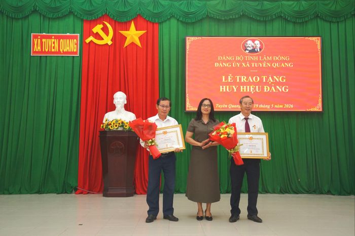Đồng chí Trần Thị Thanh Nhàn, Phó Bí thư Thường trực Đảng ủy xã Tuyên Quang trao tặng Huy hiệu 30 năm tuổi Đảng cho 2 đồng chí