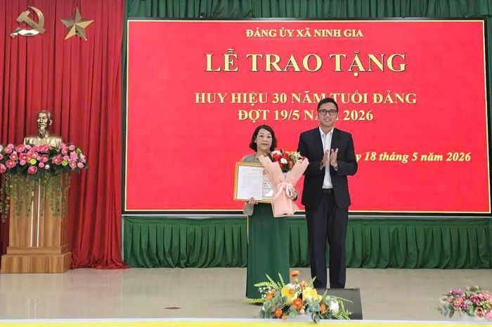 Đồng chí Nguyễn Trần Nhật Huy, Bí thư Đảng ủy, Chủ tịch HĐND xã trao Huy hiệu Đảng cho đồng chí Lê Thị Ngọc Lan