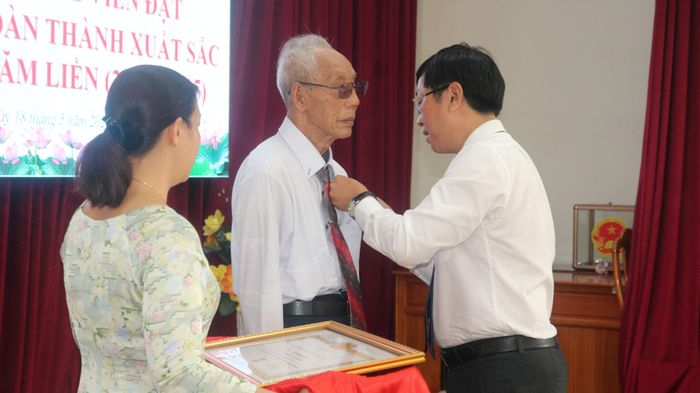Đồng chí Nguyễn Hữu Thông, Bí thư Đảng ủy phường gắn Huy hiệu 60 năm tuổi Đảng cho đảng viên Tô Thanh Cao (Chi bộ khu phố 5 - Phú Thủy)