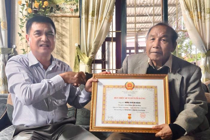 Đồng chí Đỗ Khắc Lợi, Phó Bí thư Thường trực Đảng ủy xã Lạc Dương trao tặng Huy hiệu 40 năm tuổi Đảng cho đảng viên Đơng Gur Ha Bách