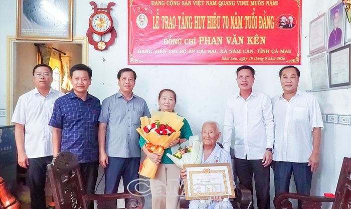 Trưởng ban Nội chính Tỉnh ủy Trần Hữu Phước (thứ hai từ phải sang) trao Huy hiệu Đảng, tặng hoa chúc mừng đồng chí Phan Văn Kên.