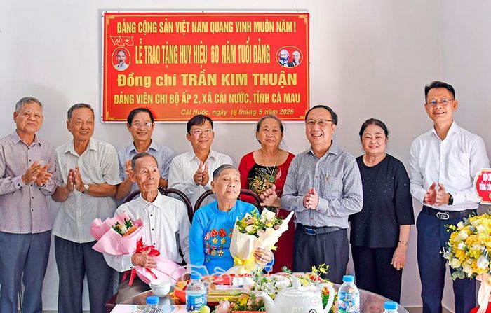 Phó Chủ tịch HĐND tỉnh Phan Hoàng Vũ cùng đại diện lãnh đạo địa phương chụp ảnh lưu niệm cùng đồng chí Trần Kim Thuận và gia đình.