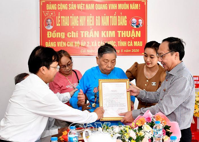 Phó Chủ tịch HĐND tỉnh Phan Hoàng Vũ (bìa phải) trao Huy hiệu 60 năm tuổi Đảng cho đồng chí Trần Kim Thuận, đảng viên Chi bộ Ấp 2, xã Cái Nước.
