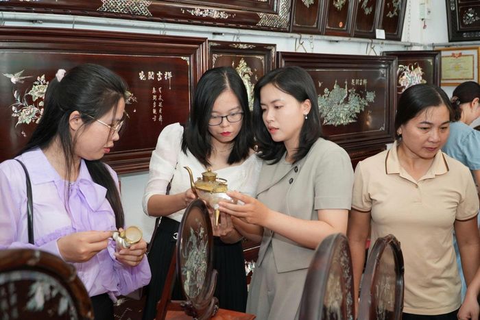 Du khách tham quan gian trưng bày sản phẩm khảm trai tại xã Chuyên Mỹ. Ảnh: ĐÌNH LỘC