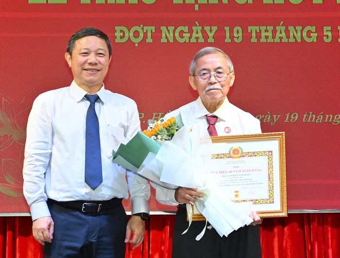 Đồng chí Dương Anh Đức trao Huy hiệu 60 năm tuổi Đảng đến đồng chí Nguyễn Văn Hoàng. Ảnh: VIỆT DŨNG