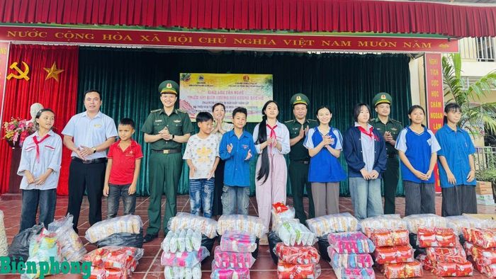 Cán bộ Đồn Biên phòng Nậm Nhừ trao quà tặng học sinh có hoàn cảnh đặc biệt khó khăn xã Nà Hỳ, tỉnh Điện Biên. Ảnh: Mùa Tùng