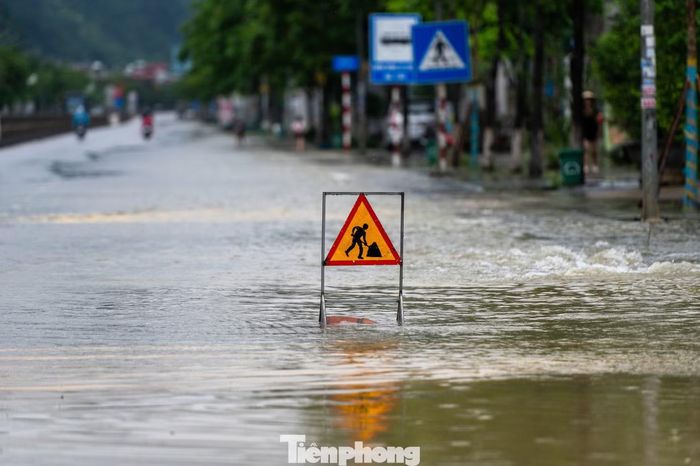 Trong khi đó trên quốc lộ 18 đoạn qua phường Quang Hanh nhiều điểm bị ngập sâu, cơ quan chức năng phải cắm biển cảnh báo.