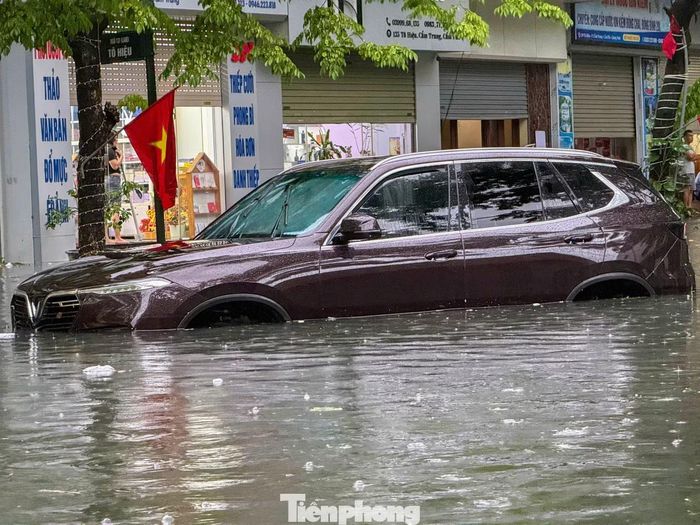 Trong khi đó dưới mặt đường vẫn còn nhiều ôtô bị mắc kẹt, nước ngập qua hết bánh xe.