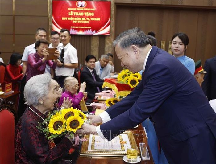 Tổng Bí thư, Chủ tịch nước Tô Lâm tặng hoa chúc mừng các đảng viên nhận Huy hiệu Đảng. Ảnh: Thống Nhất/TTXVN
