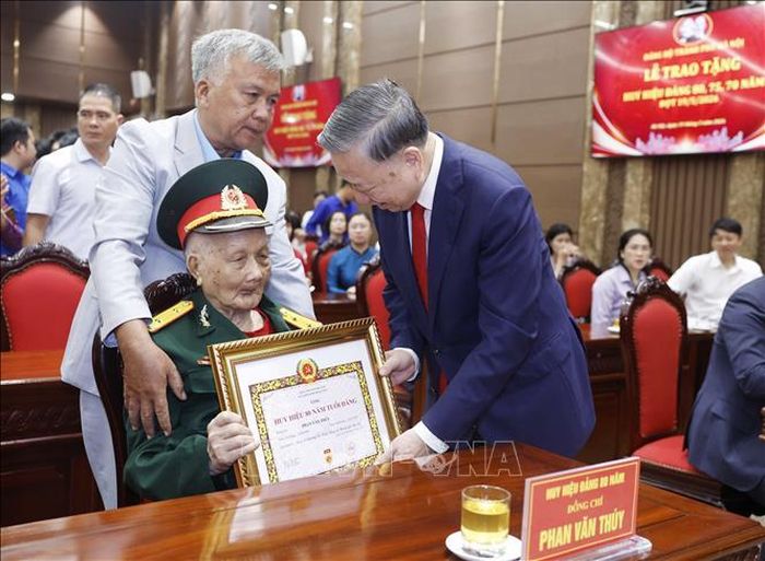 Tổng Bí thư, Chủ tịch nước Tô Lâm trao giấy chứng nhận tặng Huy hiệu 80 năm tuổi Đảng cho đảng viên lão thành Phan Văn Thúy (Đảng bộ phường Ba Đình). Ảnh: Thống Nhất/TTXVN