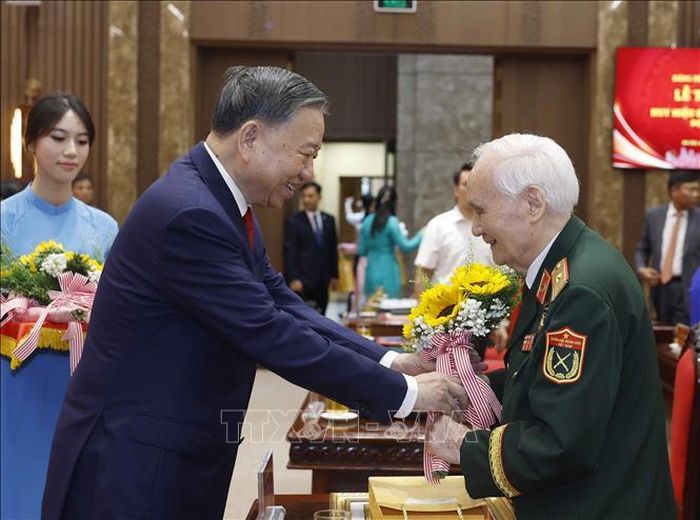 Tổng Bí thư, Chủ tịch nước Tô Lâm tặng hoa chúc mừng các đảng viên nhận Huy hiệu Đảng. Ảnh: Thống Nhất/TTXVN