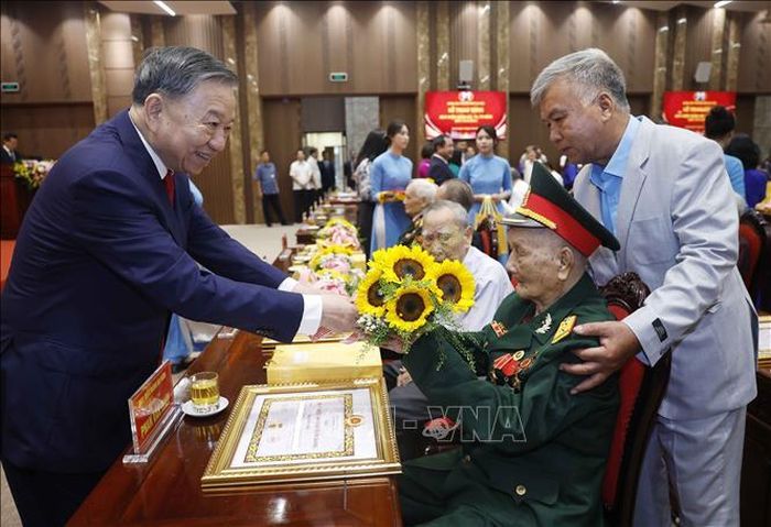 Tổng Bí thư, Chủ tịch nước Tô Lâm tặng hoa chúc mừng các đảng viên nhận Huy hiệu Đảng. Ảnh: Thống Nhất/TTXVN
