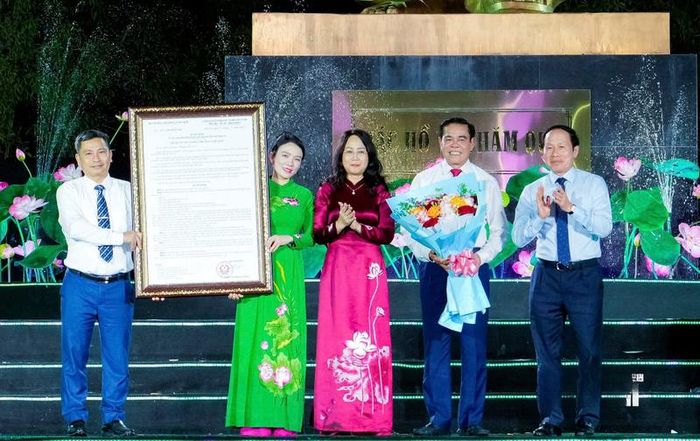 Phó Thủ tướng Lê Tiến Châu và Bộ trưởng Bộ Văn hóa, Thể thao và Du lịch Lâm Thị Phương Thanh trao Quyết định công nhận Khu du lịch quốc gia Kim Liên; tặng hoa chúc mừng tỉnh Nghệ An. Ảnh: Thành Duy