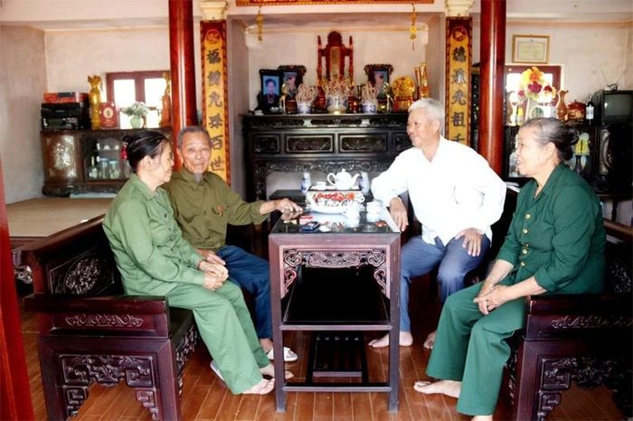 Cựu TNXP Đỗ Trọng Ơn (thứ hai từ trái sang) ôn lại kỷ niệm với cán bộ Hội Cựu TNXP xã và em gái.