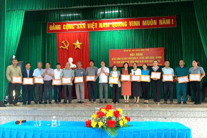 Chị K'My (đứng thứ 4 từ bên trái) nhận giấy khen có nhiều thành tích tiêu biểu trong học tập và làm theo tư tưởng, đạo đức, phong cách Hồ Chí Minh